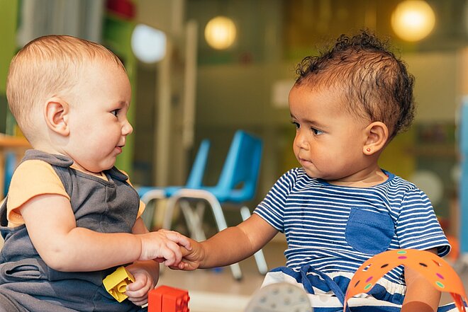 Zwei Kleinkinder nehmen in einem Spielzimmer an LENA-Gruppen-Aktivitäten der AWO in Mönchengldbach teil und unterstützen so ihre Entwicklung von Kindern und ihre frühkindliche Förderung.